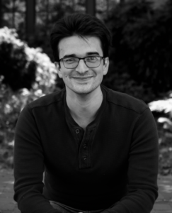 Black and White photo of young white man sitting outside