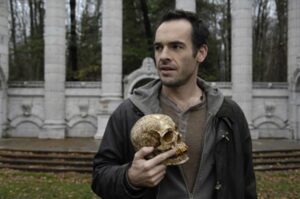 Paul Blackthorne as Harry Dresden holding Bob the Skull