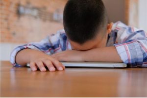 A Young Person Asleep on their computer