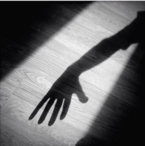 A creepy hand shadow coming through a doorway