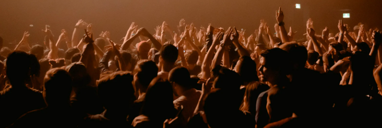 A group of people applauding at a rock concert