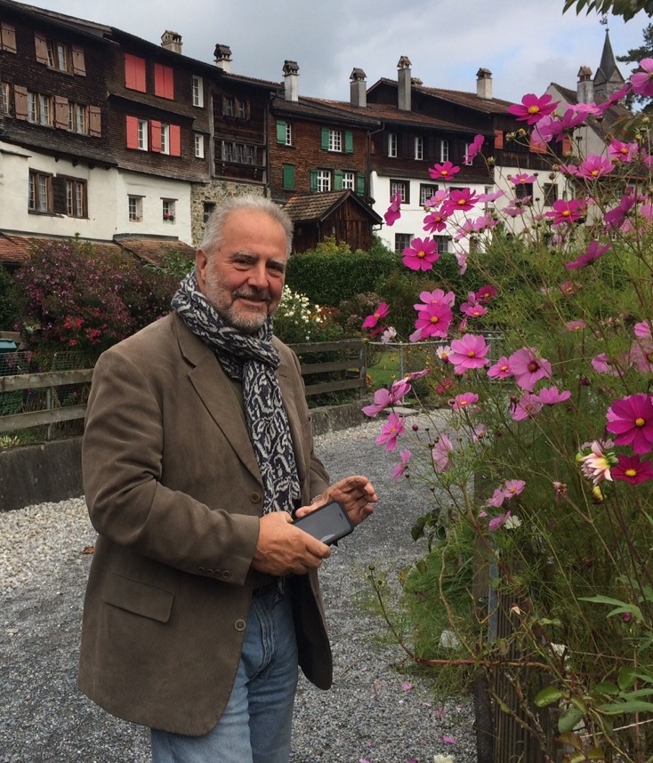 Eric Lucas standing next to flowers in the Swiss Alps