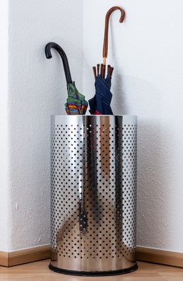 A metallic umbrella stand in an otherwise empty room