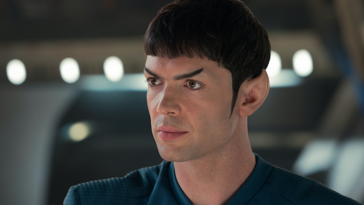 A young white man with a dark hair, bowl cut, and pointy ears. 