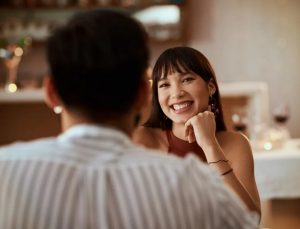 A young Asian woman is on a first date at a nice restaurant. 