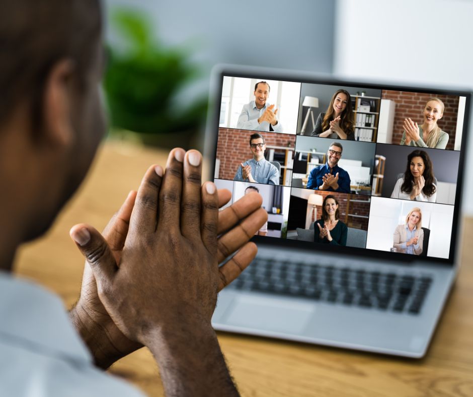 Man, desk, computer, plant, clapping, conference call, zoom, virtual meeting
