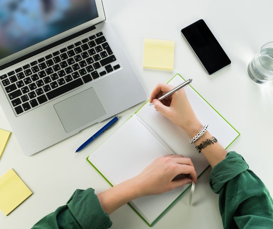 computer, notebook, phone, pens, writing