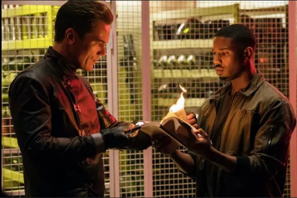 Two men watching as a book burns from the movie Fahrenheit 451