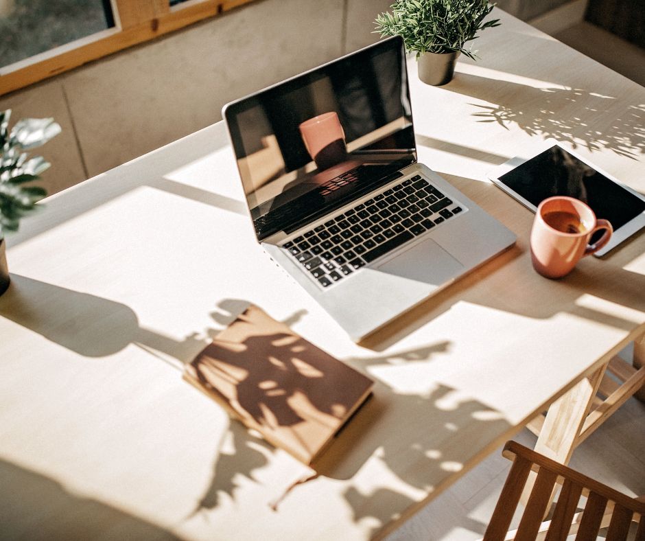 computer, cell phone, cup, shadows, desk, papers
