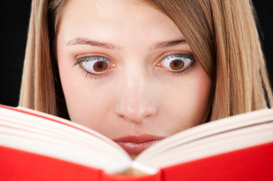 A frightened woman reads a red horror book!